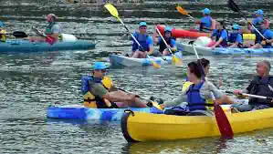 Groupe de kayakistes en file sur la Semois lors d'une descente festive de printemps